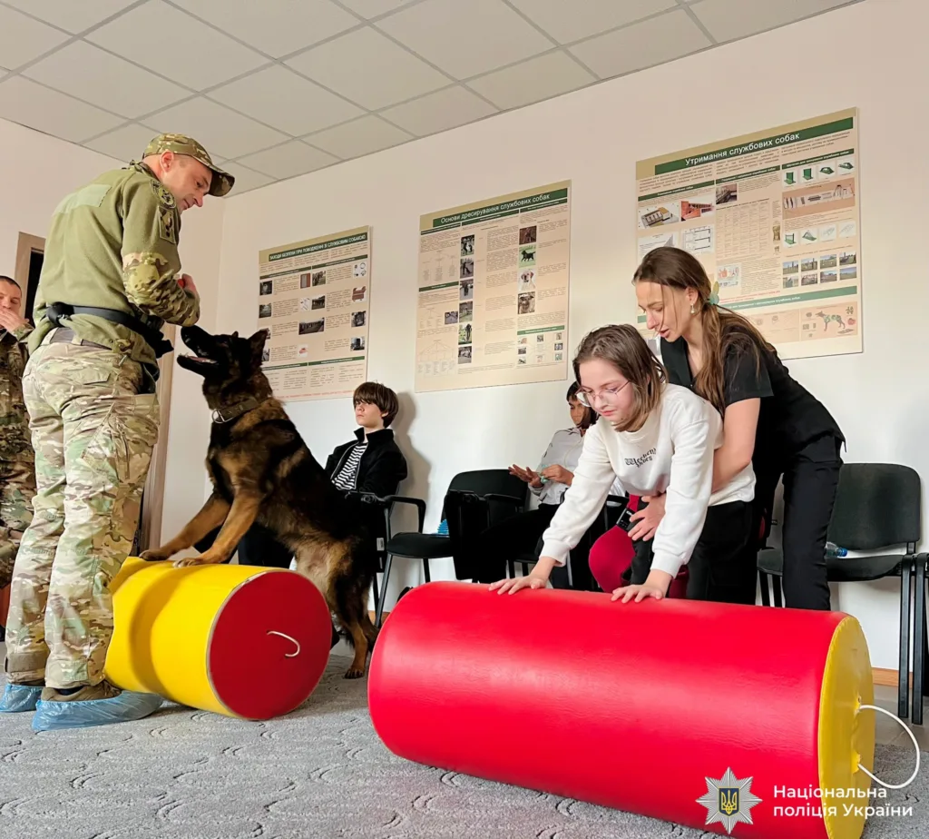 Поліцейський тренує службового собаку з дітьми