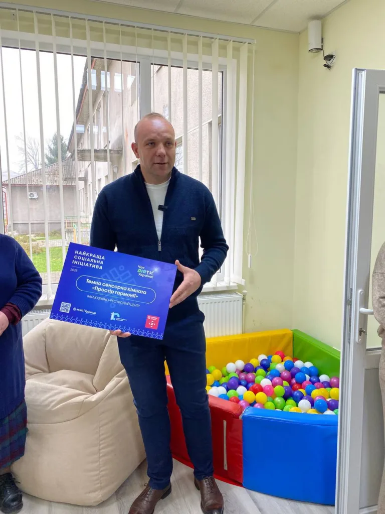 Чоловік тримає табличку біля сухого басейну з кулями