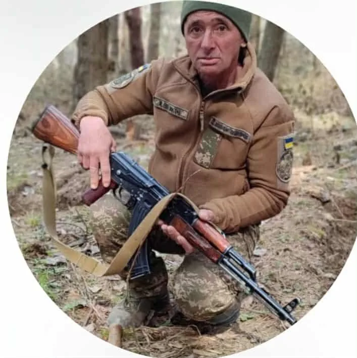 Військовий у лісі тримає автомат Калашникова