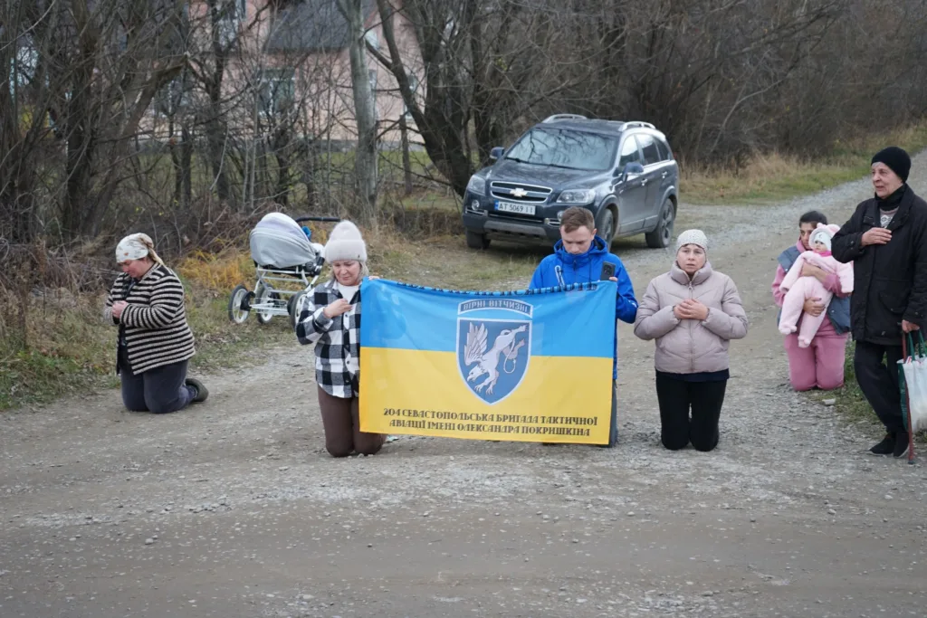 Люди на колінах з українським прапором