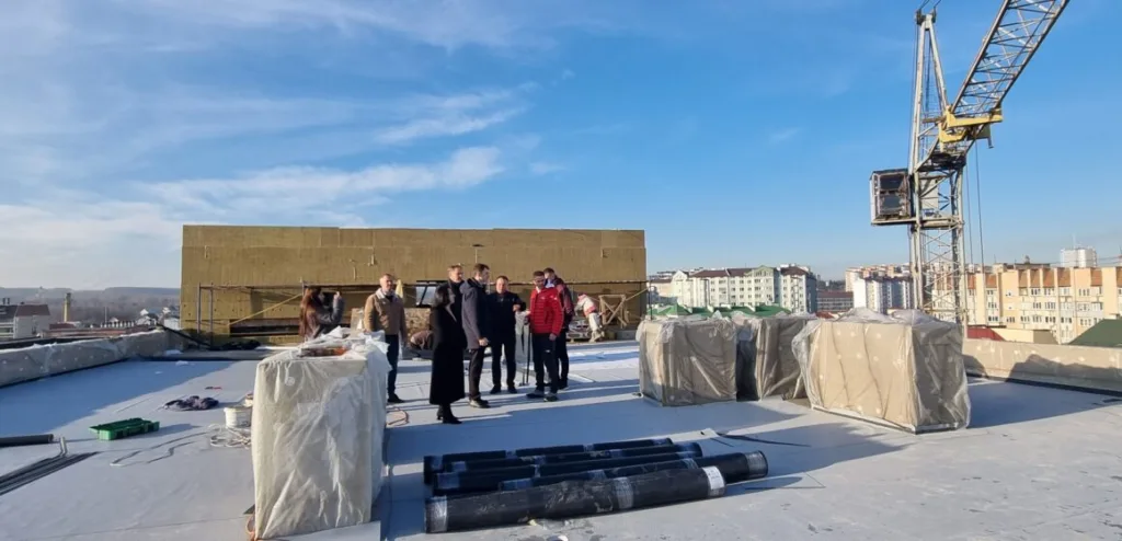 Люди оглядають будівництво на даху будівлі