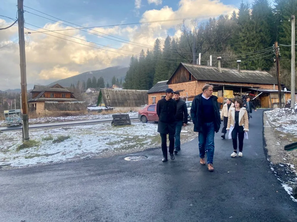Люди йдуть селом у Карпатах взимку