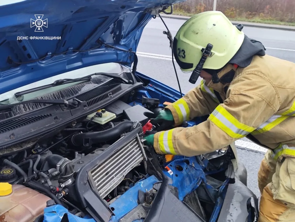 Рятувальник перевіряє двигун пошкодженого автомобіля