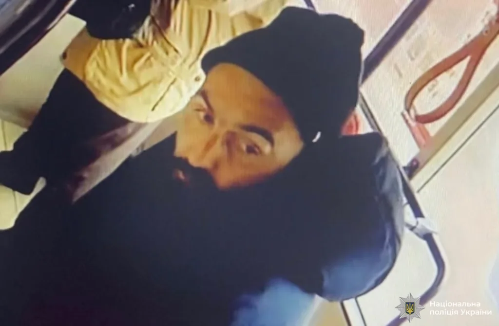 Чоловік у чорній шапці в громадському транспорті