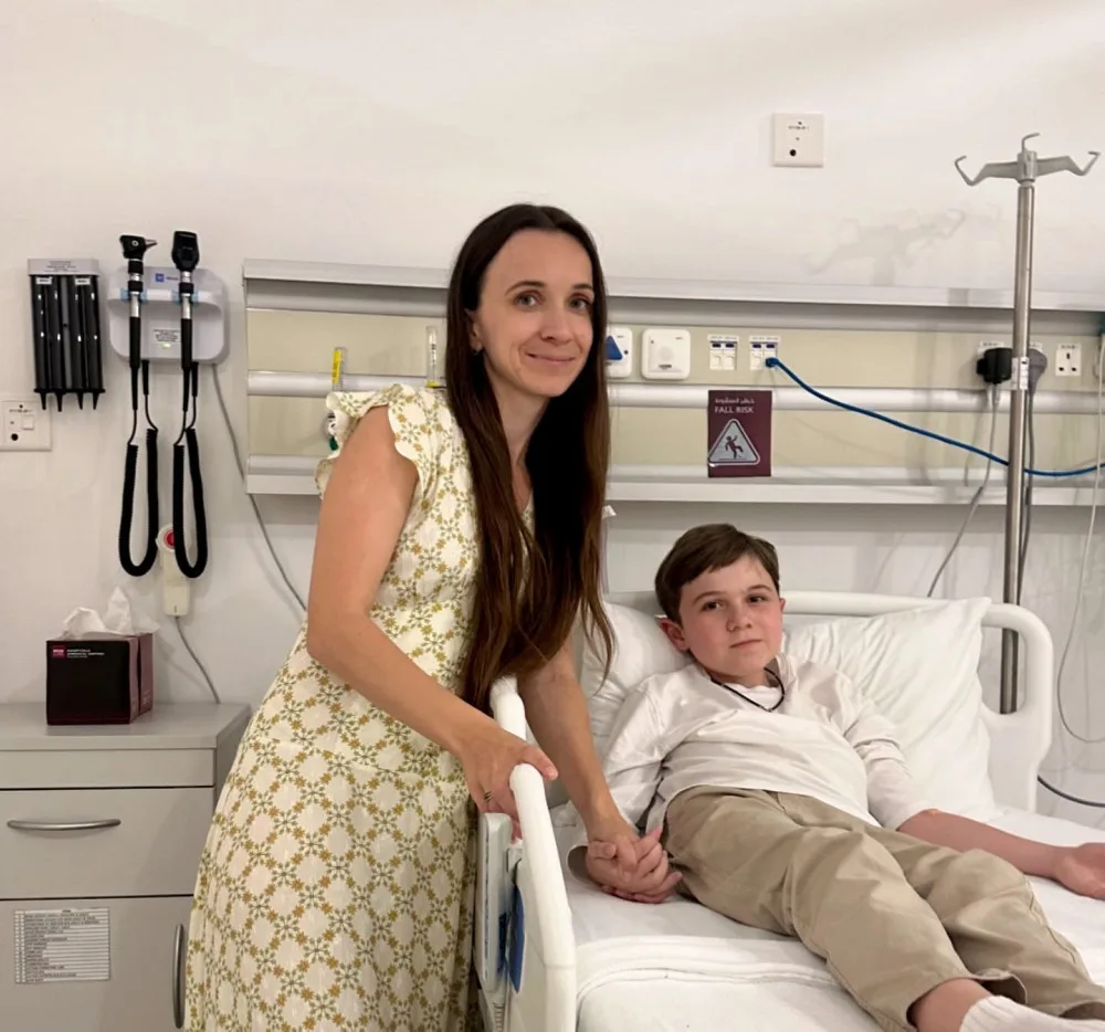 Мати тримає сина за руку в лікарні