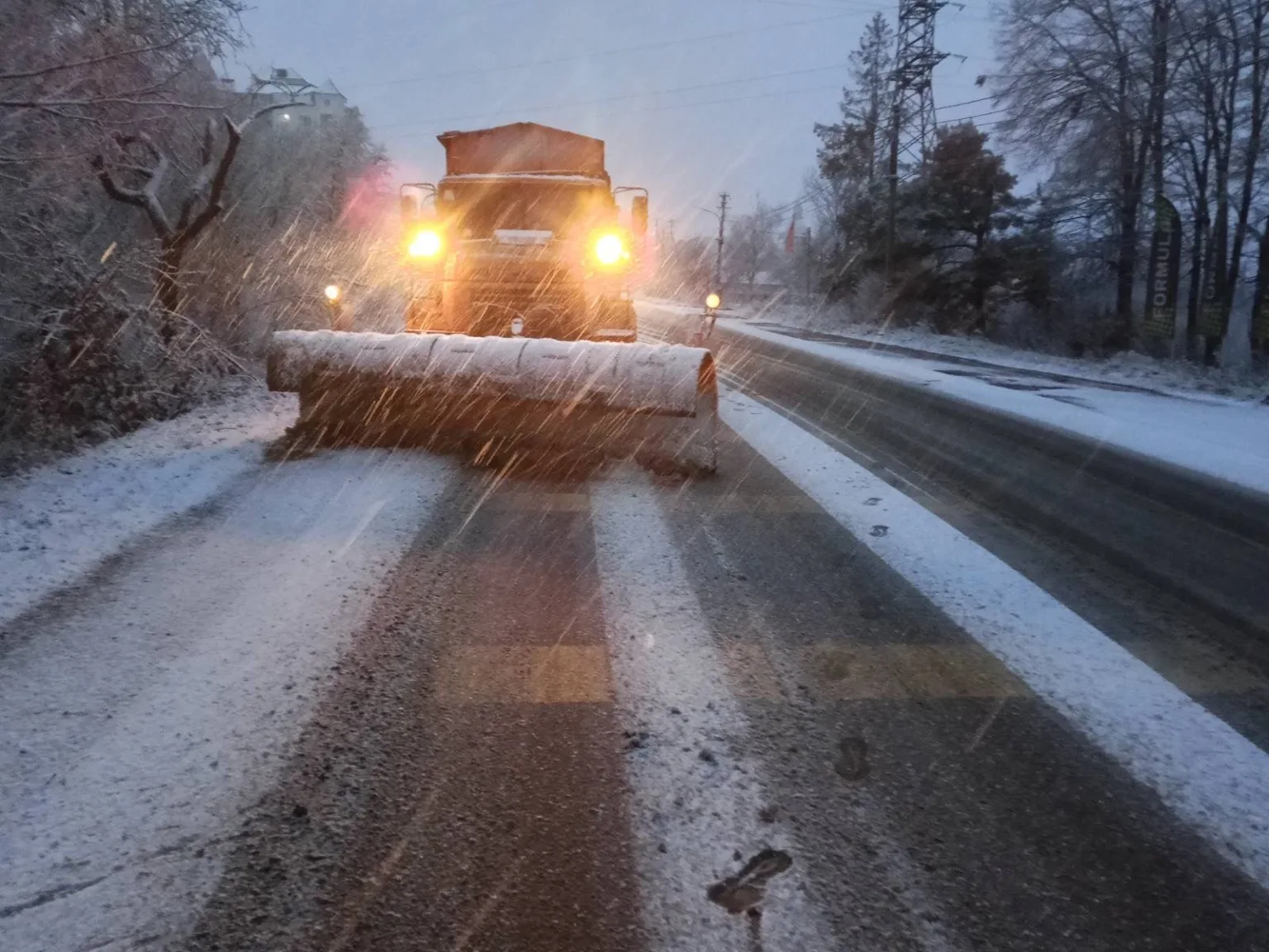 Снігоприбиральна машина очищує зимову дорогу