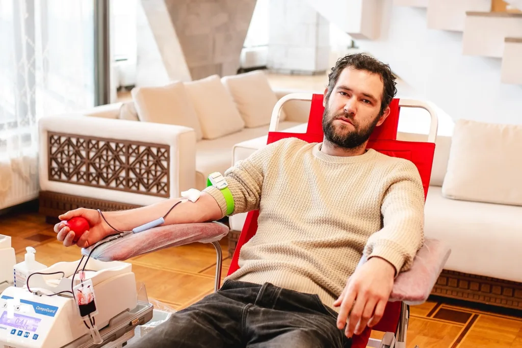 Чоловік здає кров у комфортній кімнаті