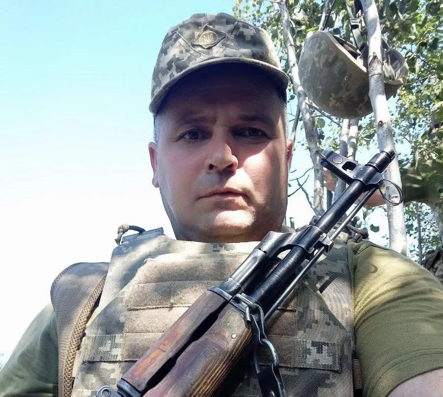 Український військовий у камуфляжі з автоматом