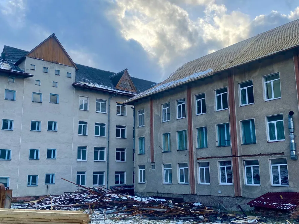 Будівля з уламками деревини на подвір’ї