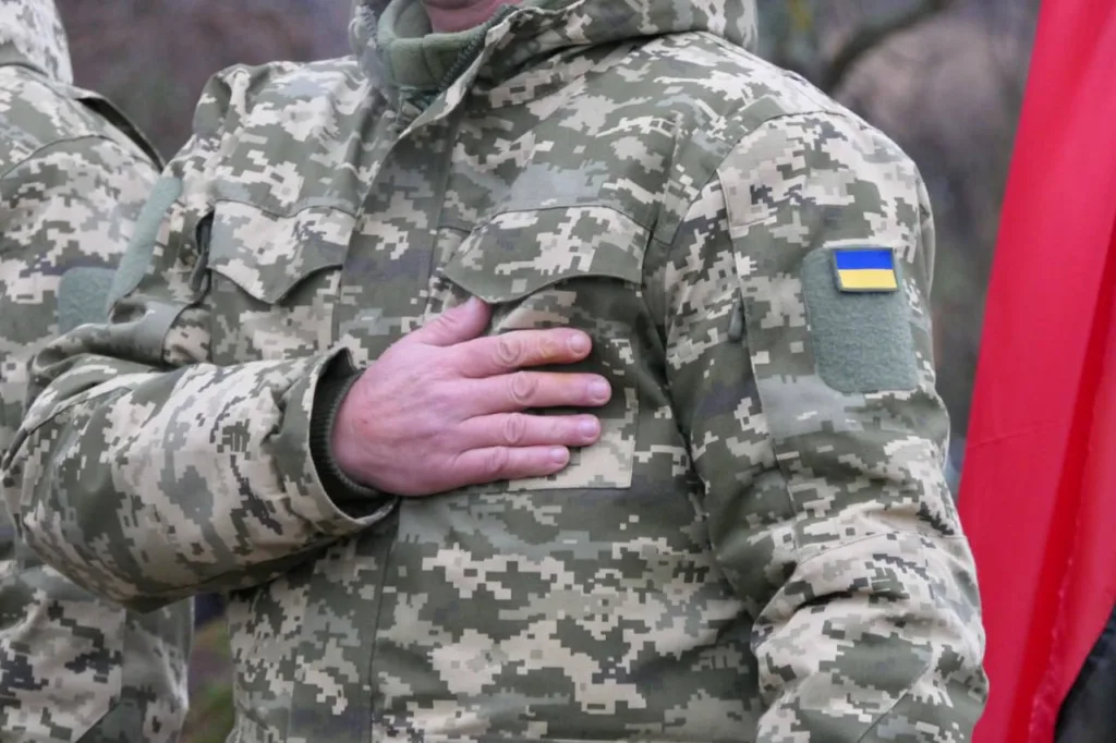 Військовий у формі з прапором України