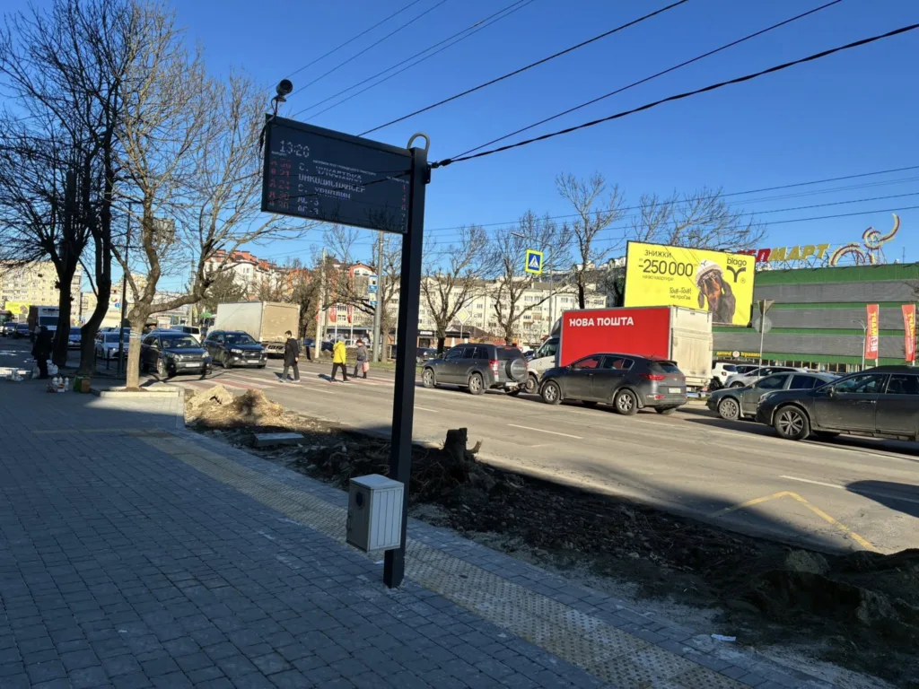 Міська вулиця з автомобілями та зупинкою транспорту