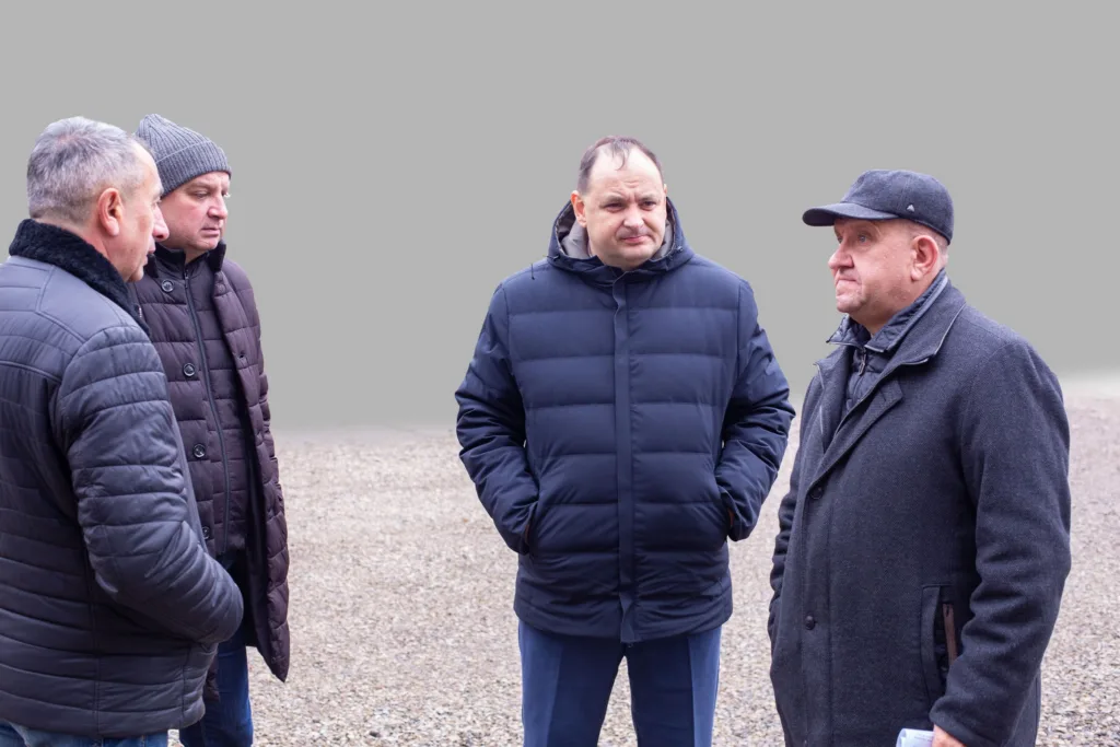 Четверо чоловіків обговорюють щось на відкритому повітрі