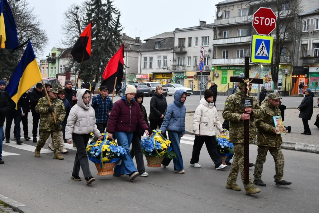 Похоронна хода з прапорами та квітами в місті