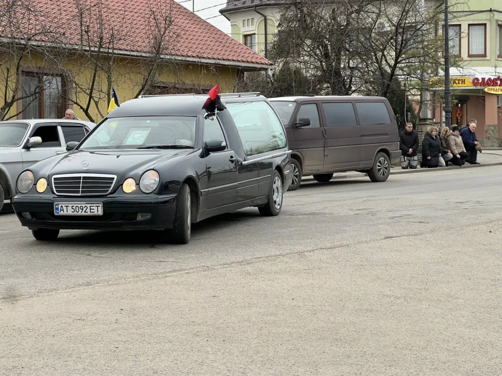 Похоронний кортеж на міській вулиці