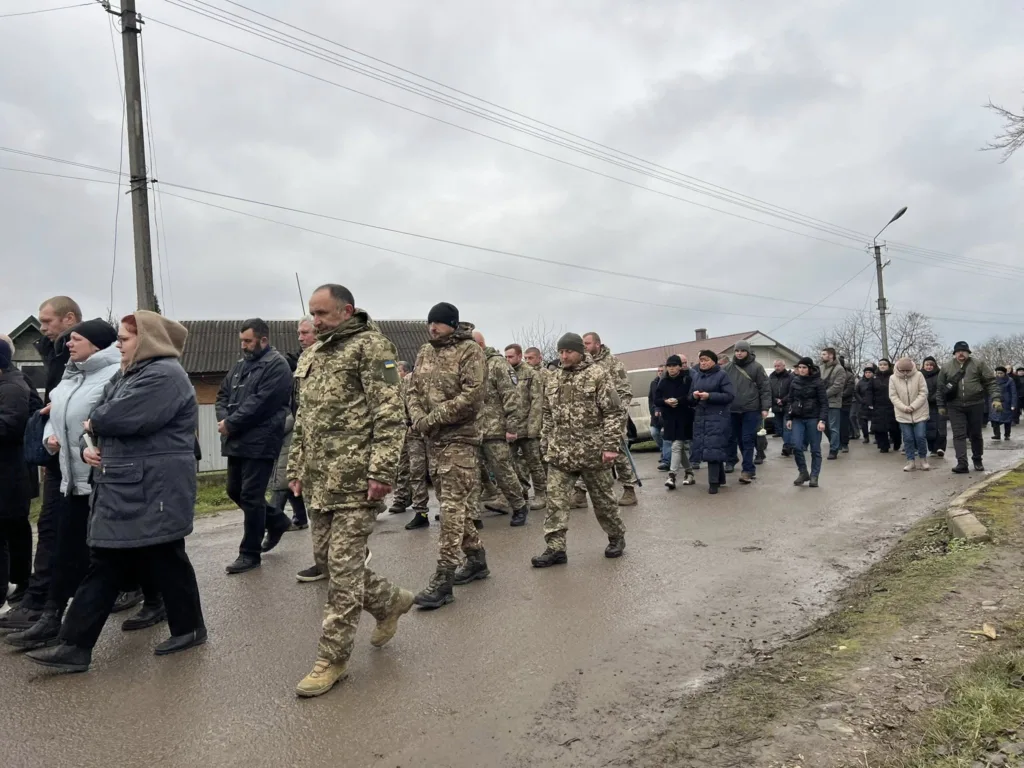 Військові та цивільні йдуть вулицею села