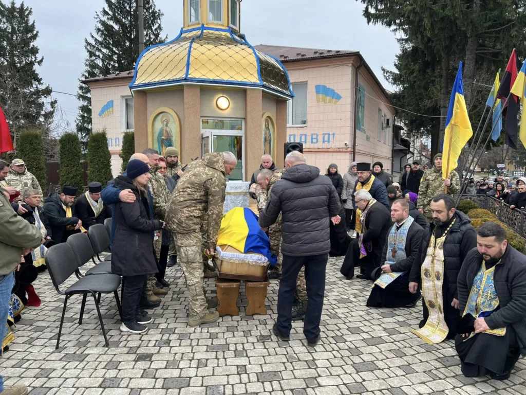 Похорон військового біля каплиці з українським прапором
