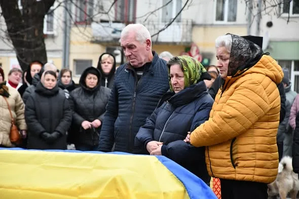 Люди прощаються з загиблим героєм під прапором України