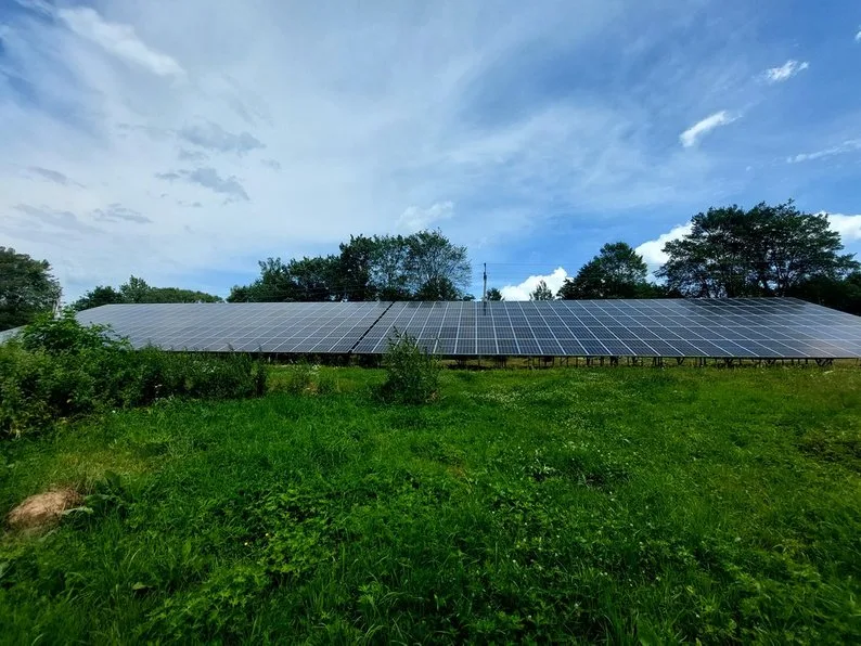 Сонячні панелі на зеленому полі під небом