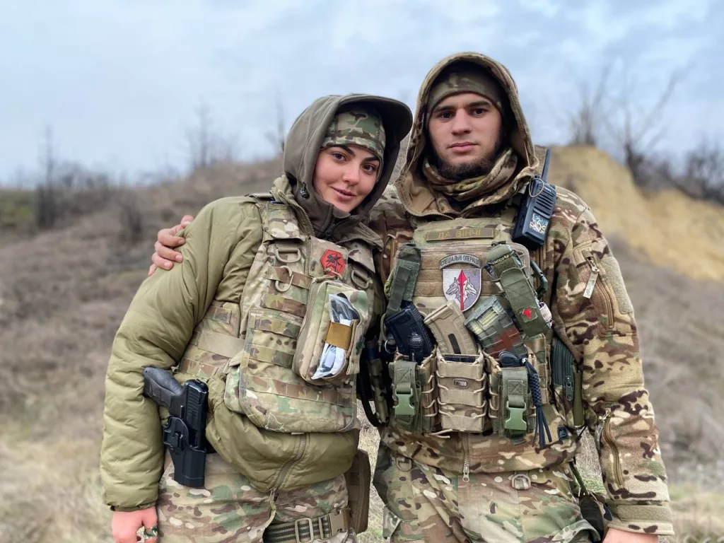 Двоє українських військових у камуфляжі на полі бою