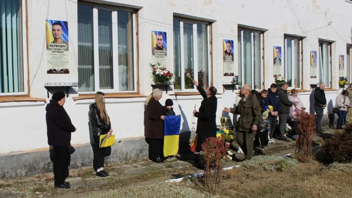 Люди вшановують загиблих героїв біля меморіальних дощок