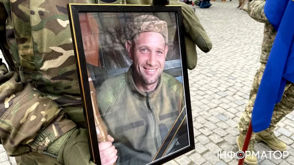 Військовий тримає фото загиблого солдата