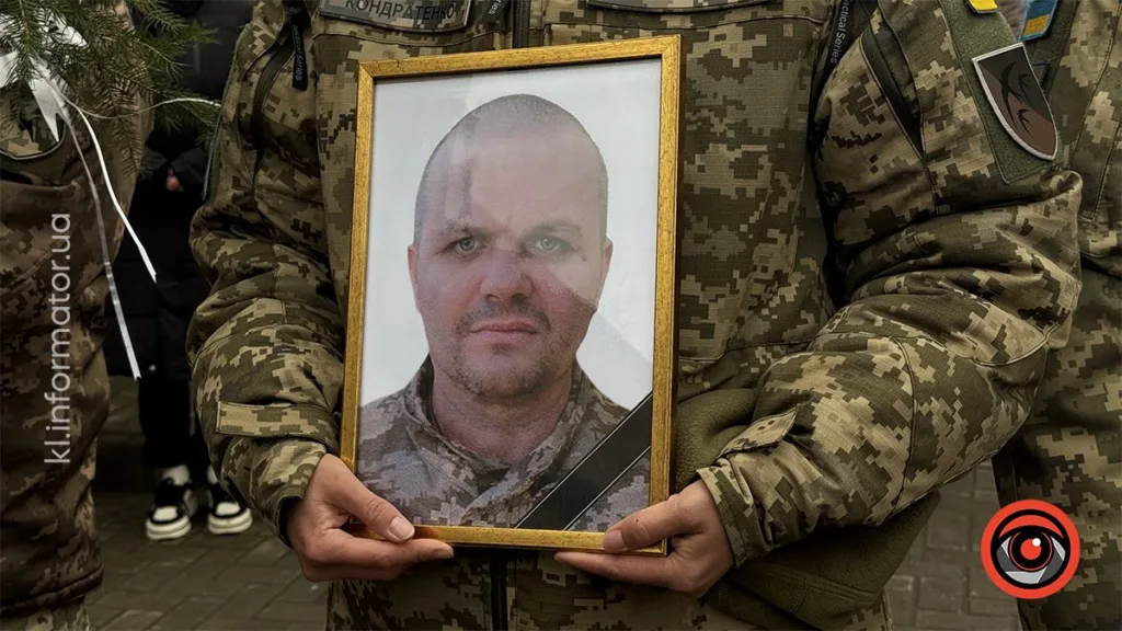 Військовий тримає портрет загиблого солдата