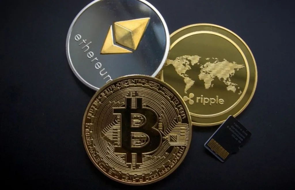 Біткойн, Ефіріум і Ріпл криптовалюти на столі