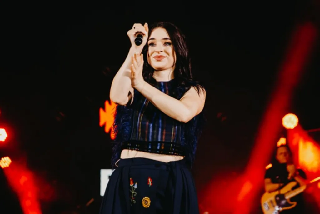 Співачка виступає на сцені з мікрофоном