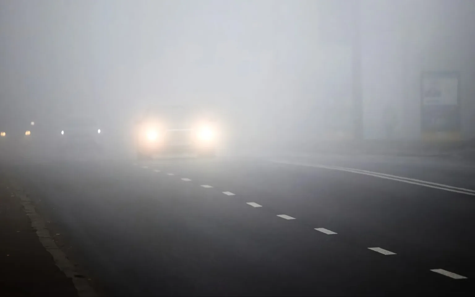 Автомобілі на дорозі в густому тумані