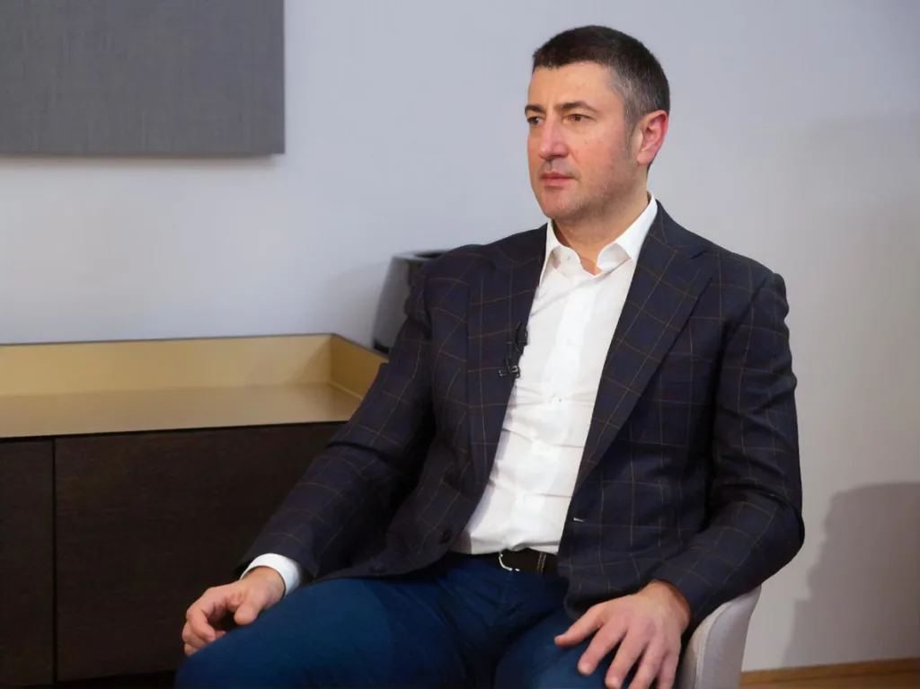 Чоловік у піджаку сидить на стільці