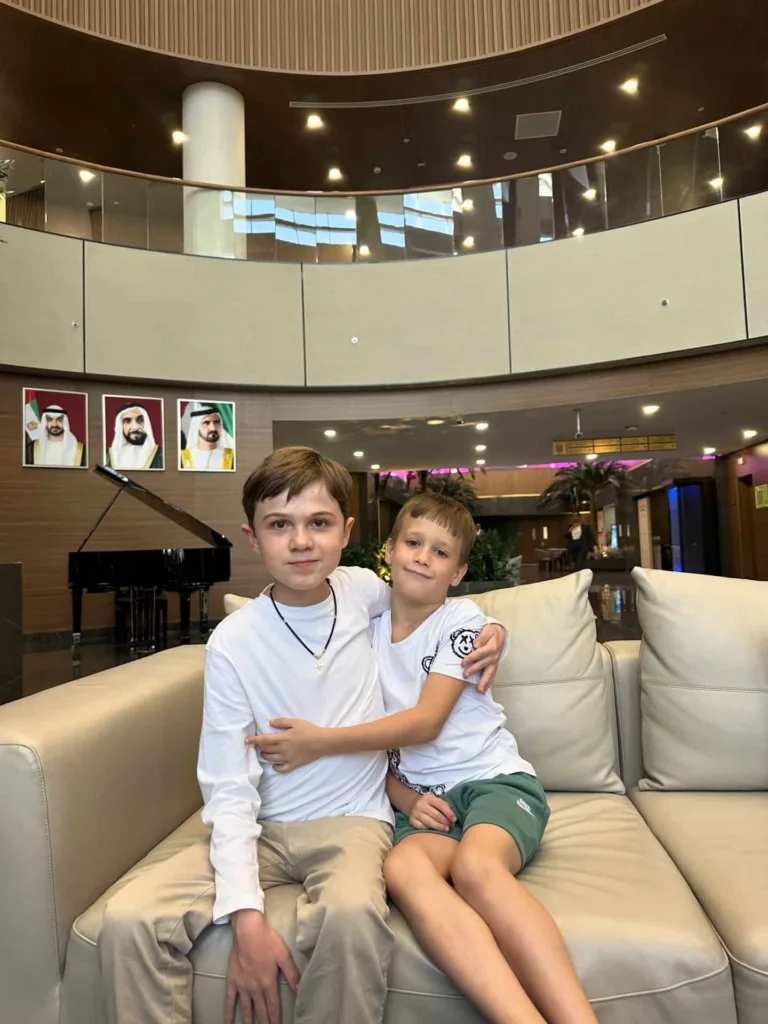 Двоє хлопців сидять на дивані в холі