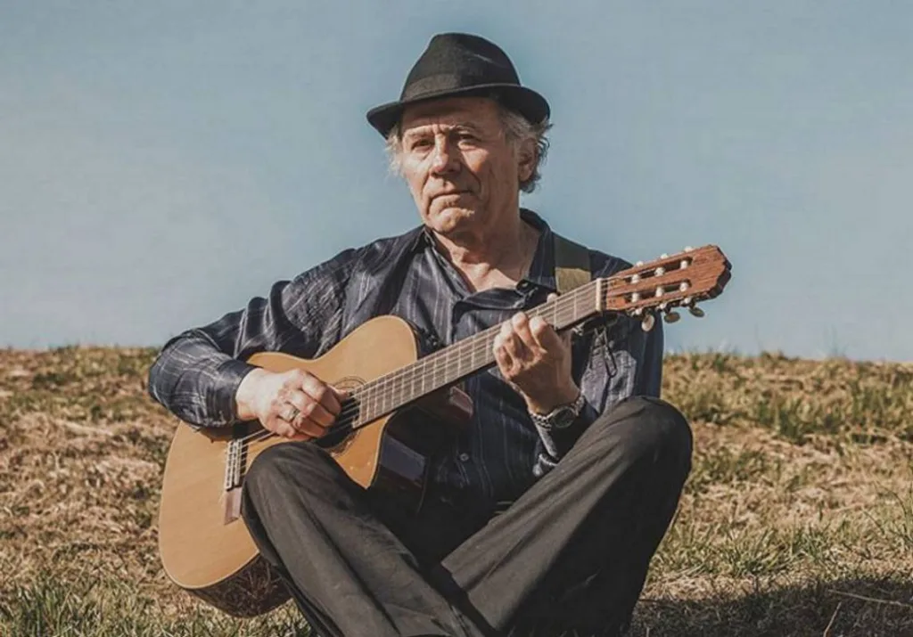 Чоловік грає на гітарі просто неба