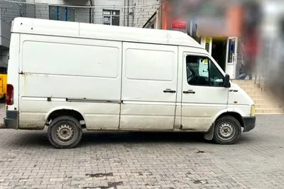 Білий вантажний фургон припаркований біля магазину