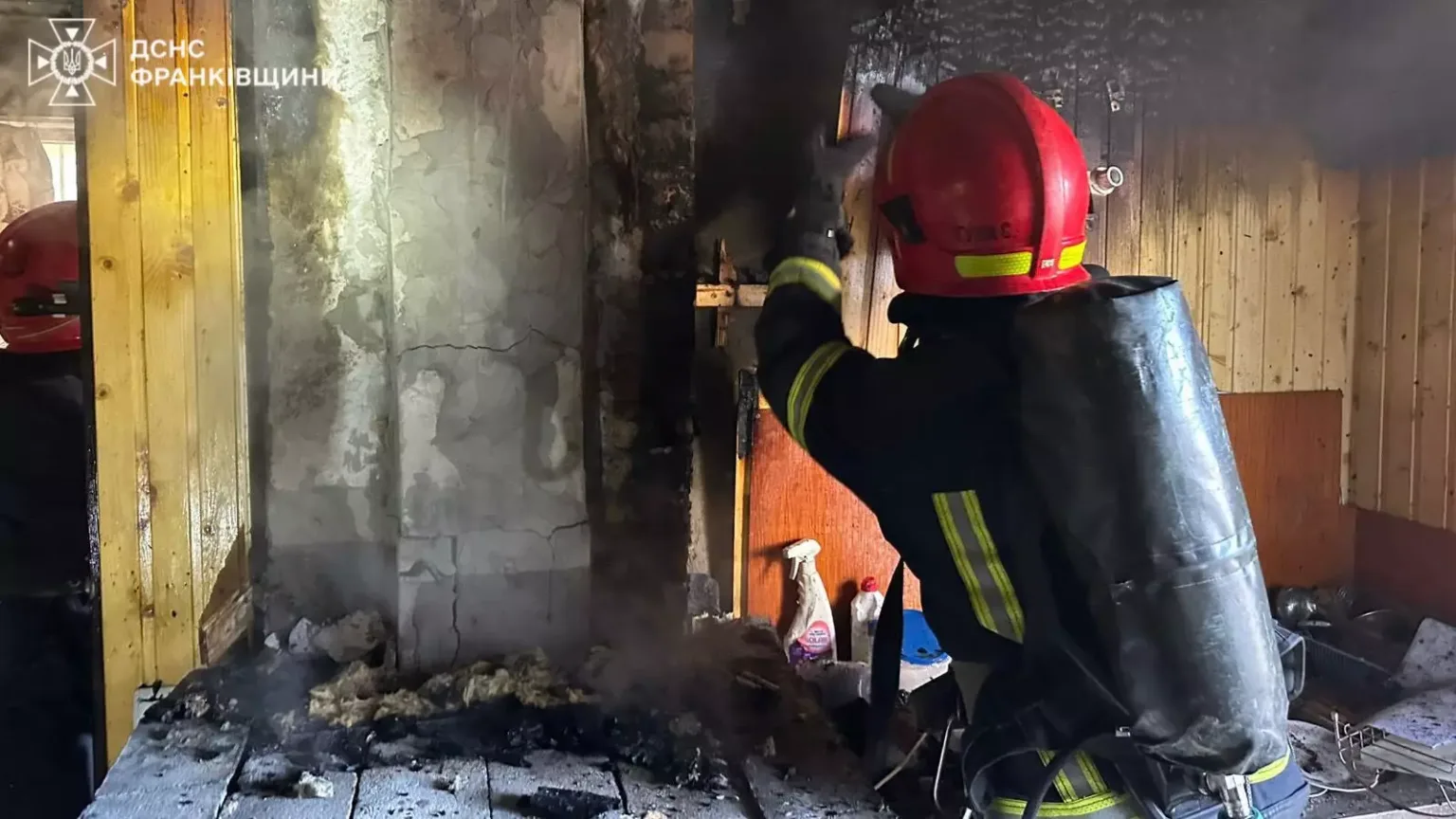 Пожежник гасить вогонь у пошкодженому приміщенні