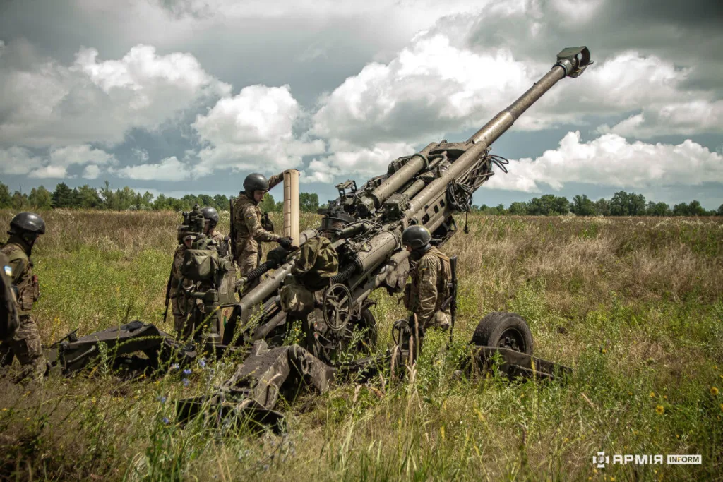 Військові обслуговують артилерійську гармату на полі