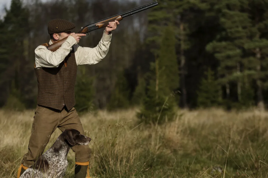 Мисливець із собакою у лісі на полюванні