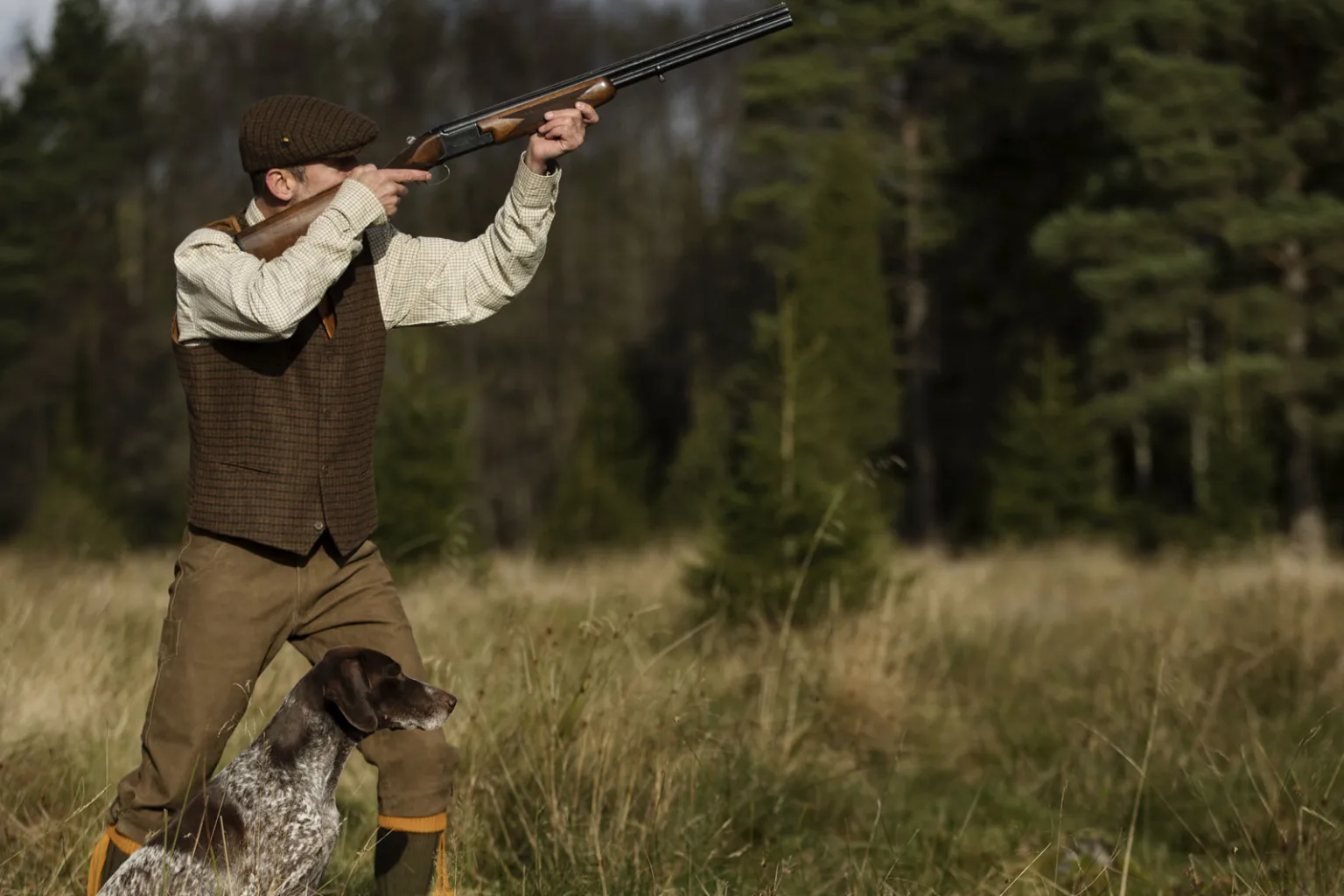 Мисливець із собакою у лісі на полюванні