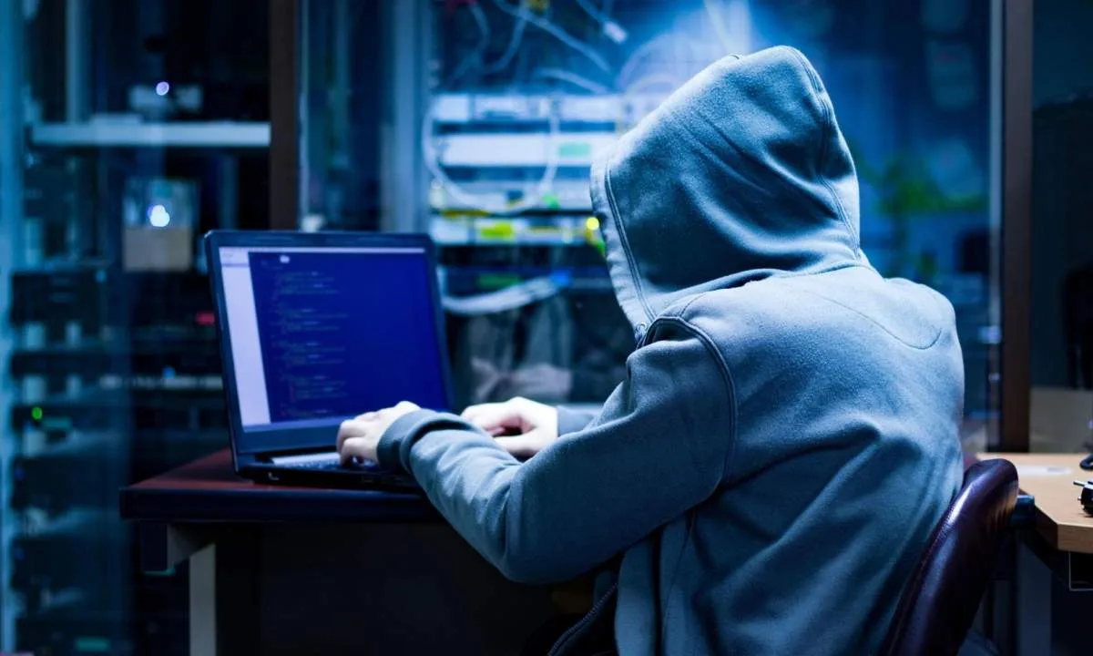 Хакер у худі працює за ноутбуком