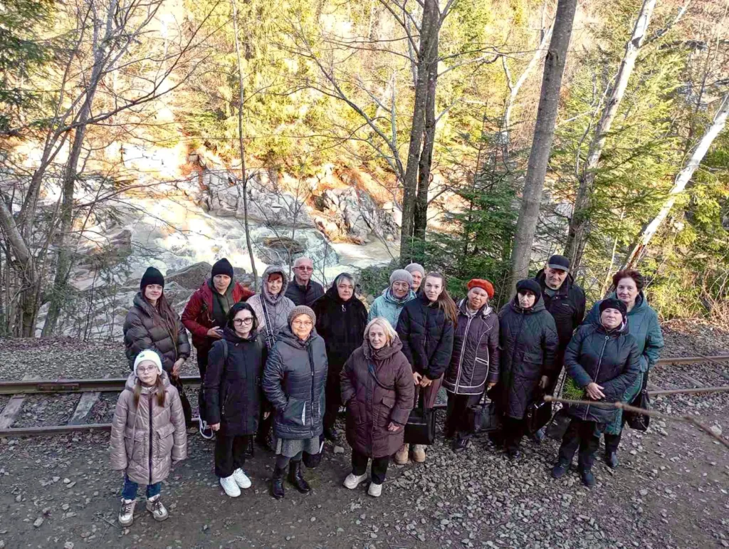 Група людей на природі біля річки і лісу