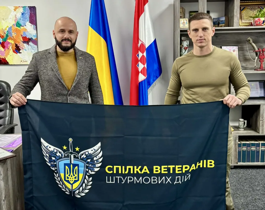 Двоє чоловіків тримають прапор Спілки ветеранів