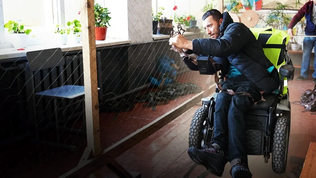 Чоловік у інвалідному візку працює всередині приміщення