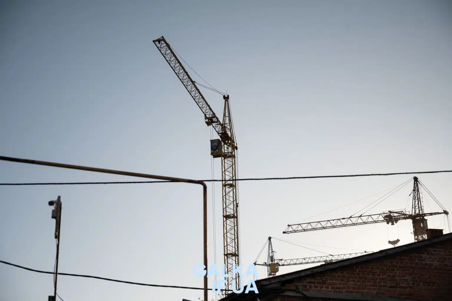 Будівельні крани над міськими дахами