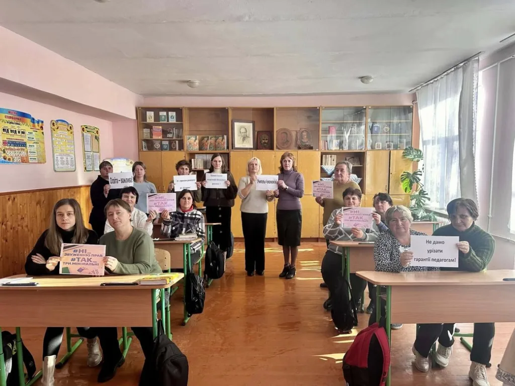 Вчителі тримають плакати на уроці у класі