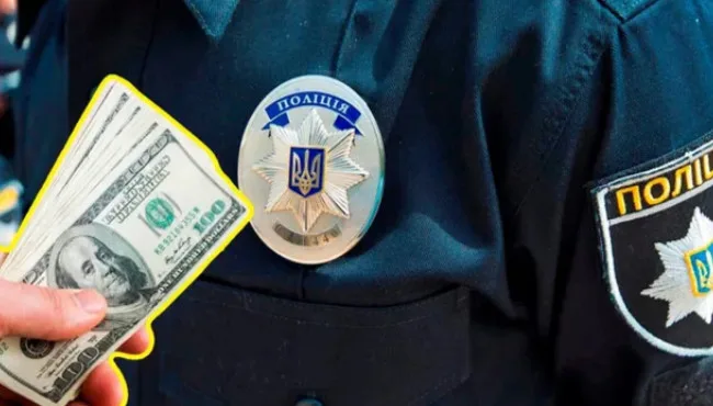 Гроші в руках перед українським поліцейським