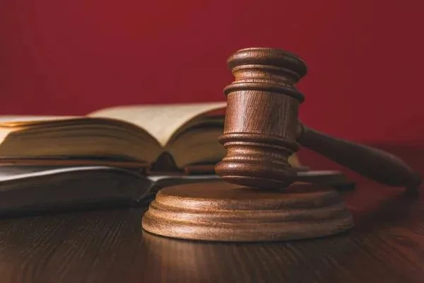 Суддівський молоток і відкрита книга закону