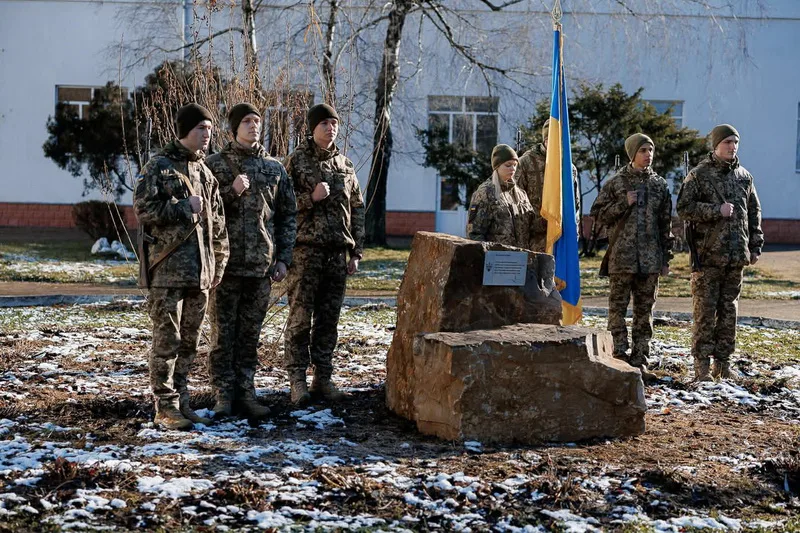 Військові біля пам'ятного каменя з прапором України