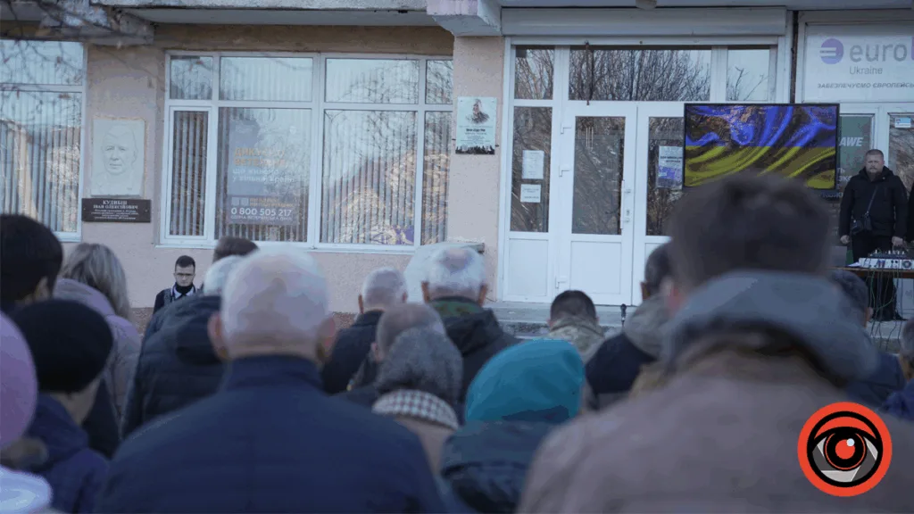 Люди вшановують ветеранів біля меморіальної дошки