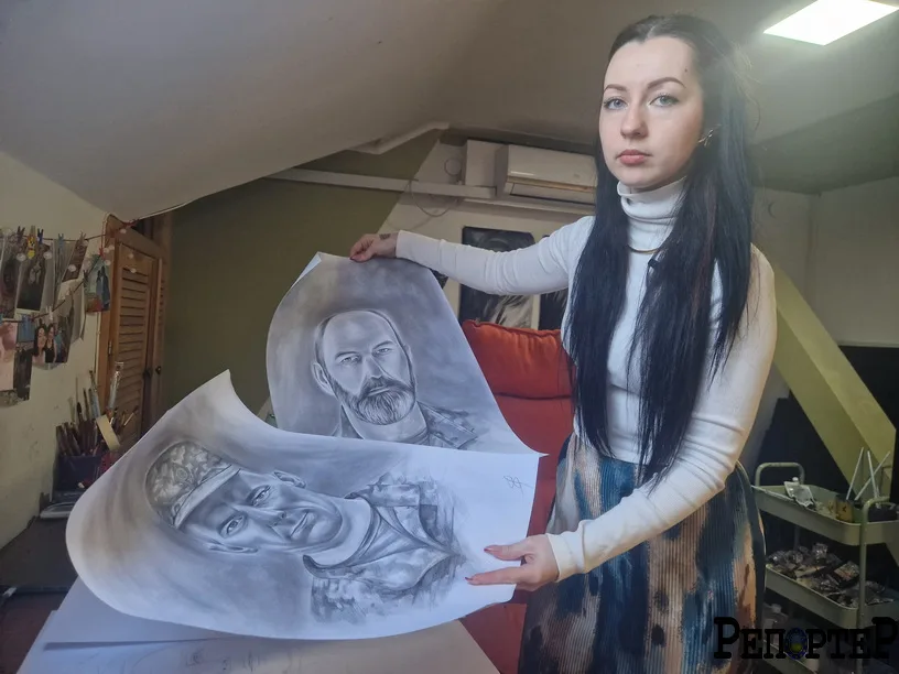 Художниця тримає портрети українських військових
