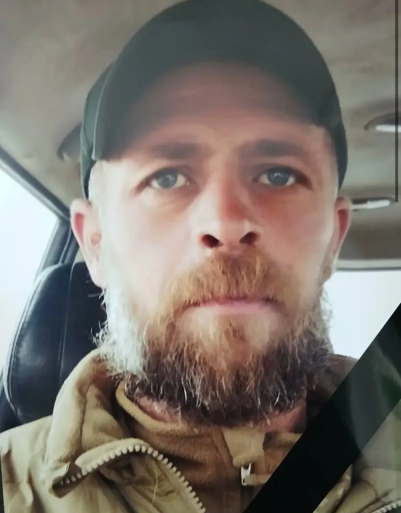 Чоловік з бородою у військовому одязі в машині