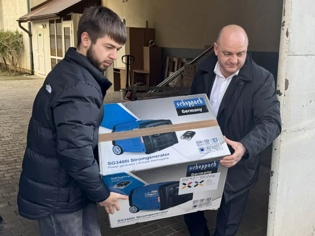 Двоє чоловіків переносять коробку з генератором